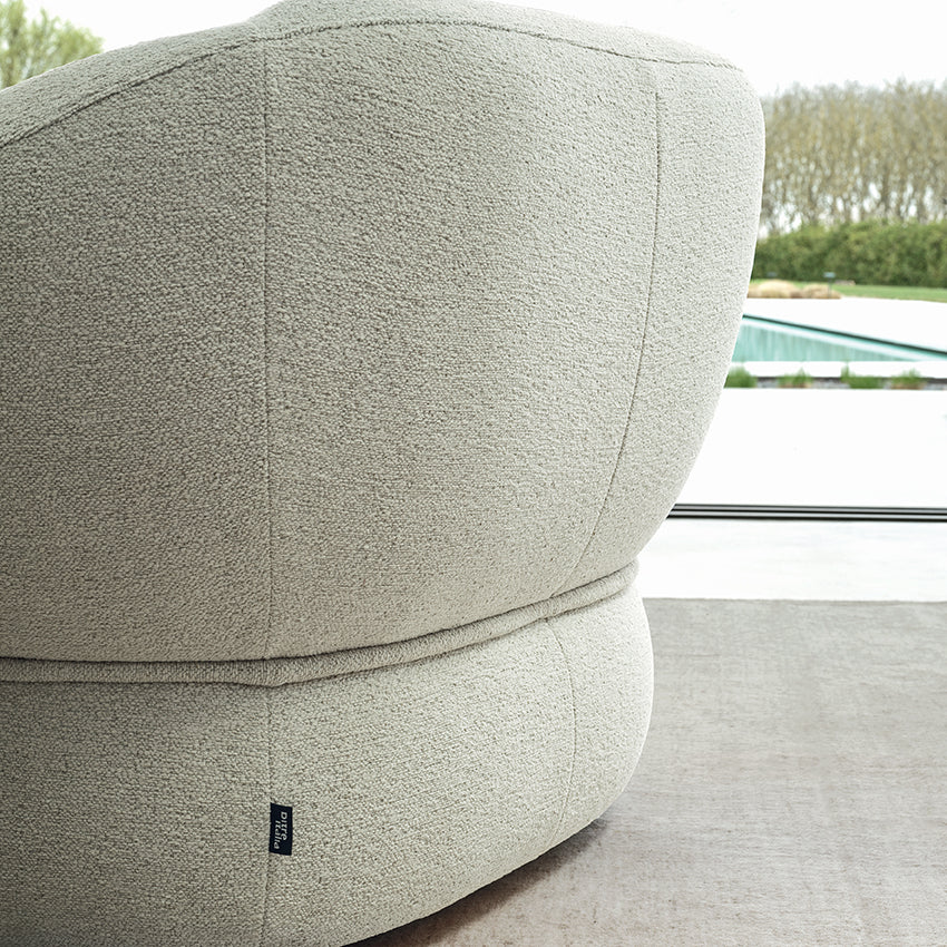 Modern gray ottoman with a textured surface in an indoor setting.