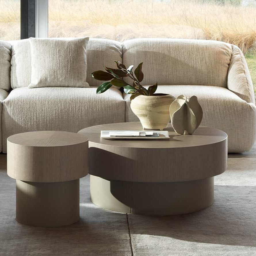 Modern living room with a beige sectional sofa, coffee table, and decorative items.