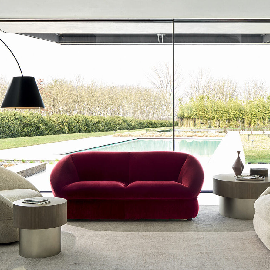 Modern living room with a red sofa, beige chairs, and a floor lamp.