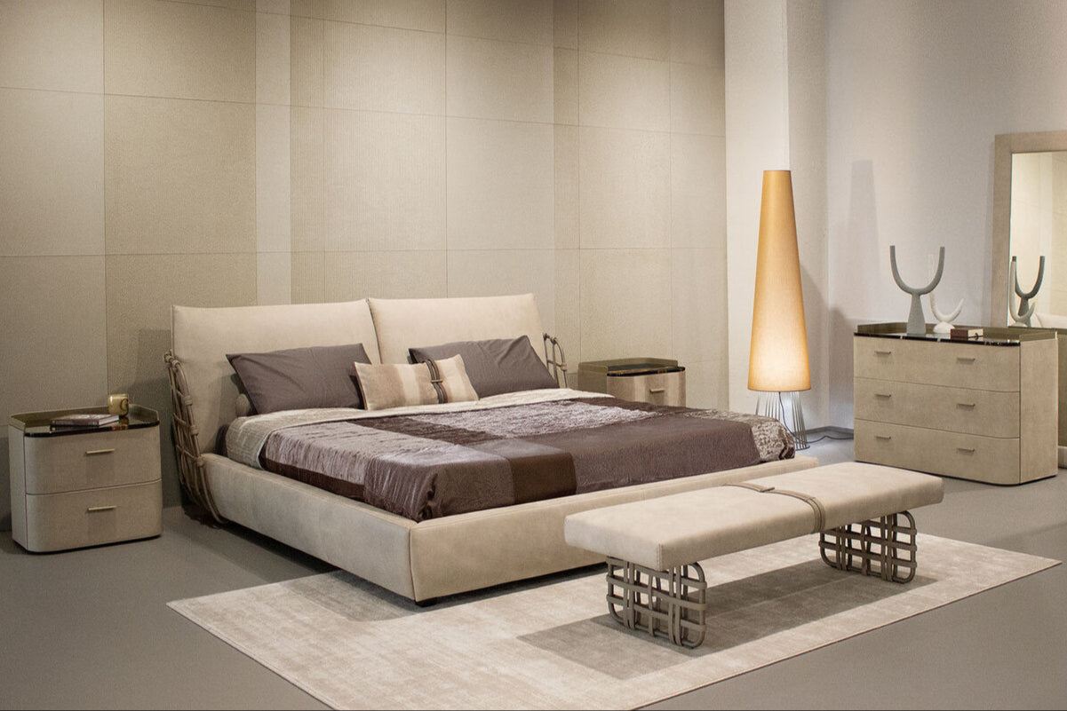 Modern bedroom with beige furniture including a bed, nightstands, and wardrobe.