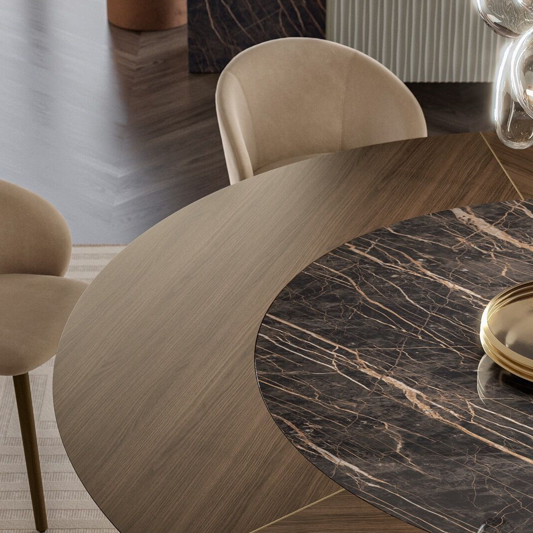 Dining room with a marble table and beige chairs, featuring a modern interior design.