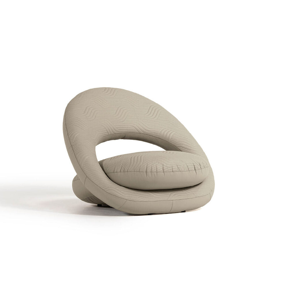 A beige upholstered occasional chair with a quilted backrest and double stitching, set against a white background.