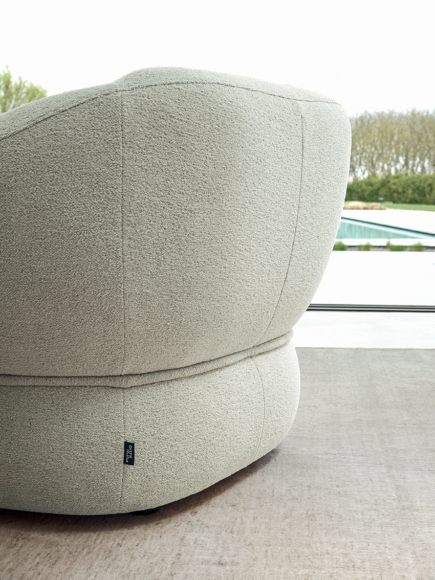 Modern gray ottoman with a textured surface in an indoor setting.