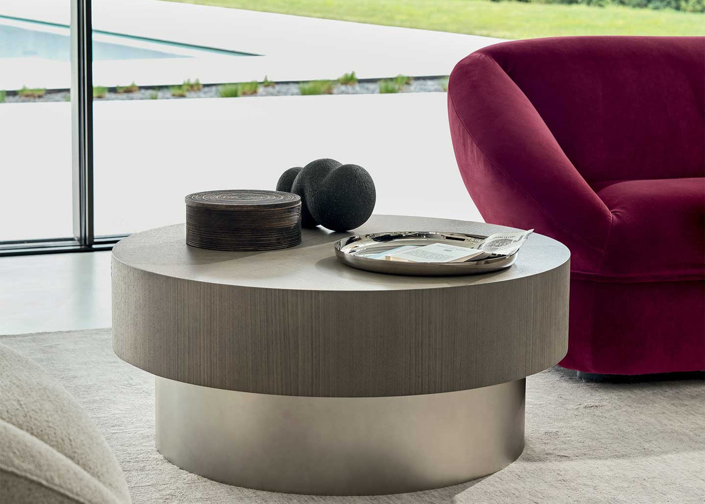Modern living room with a round coffee table and a red armchair.