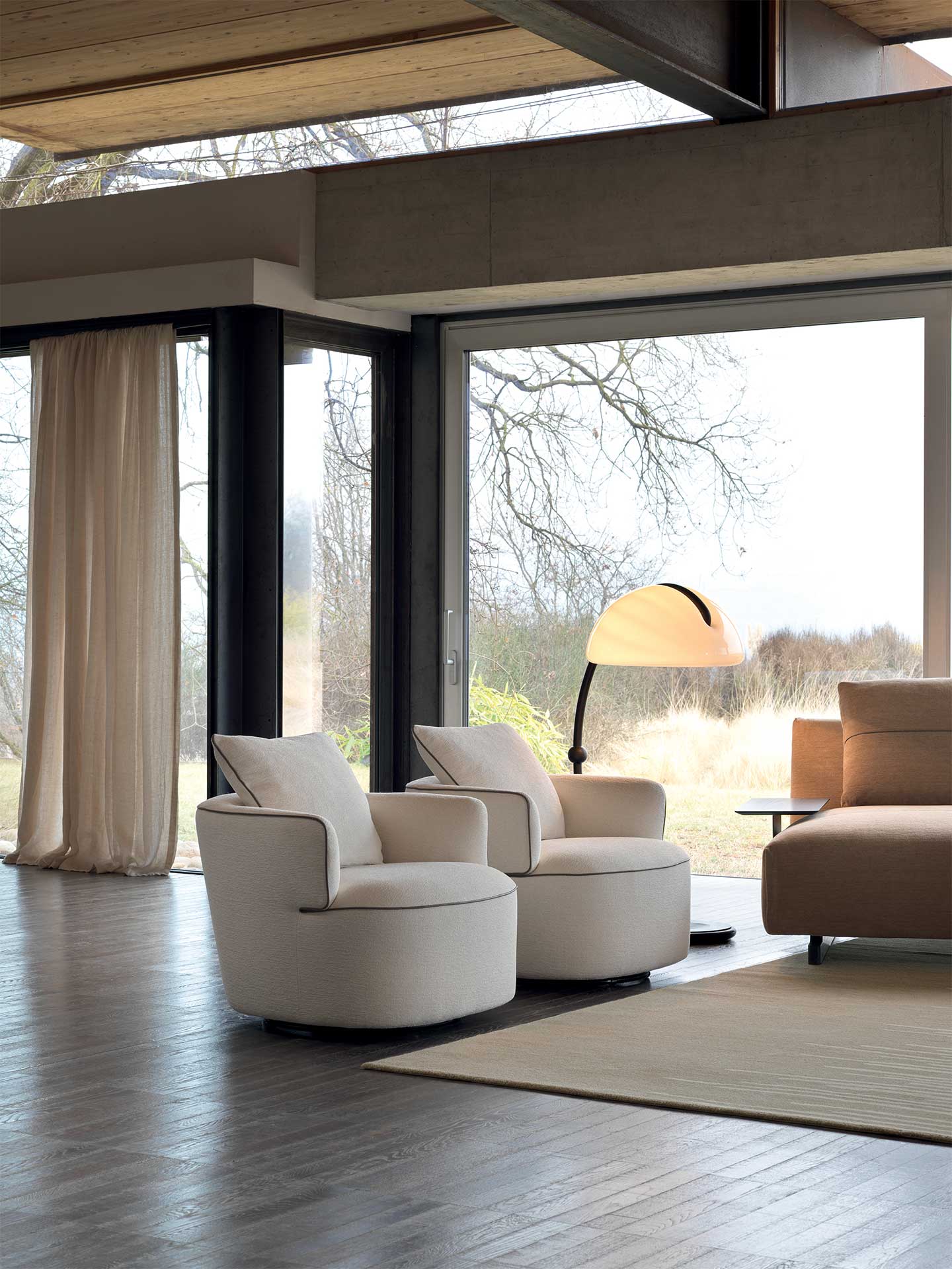 Modern living room with white armchairs and a large window view