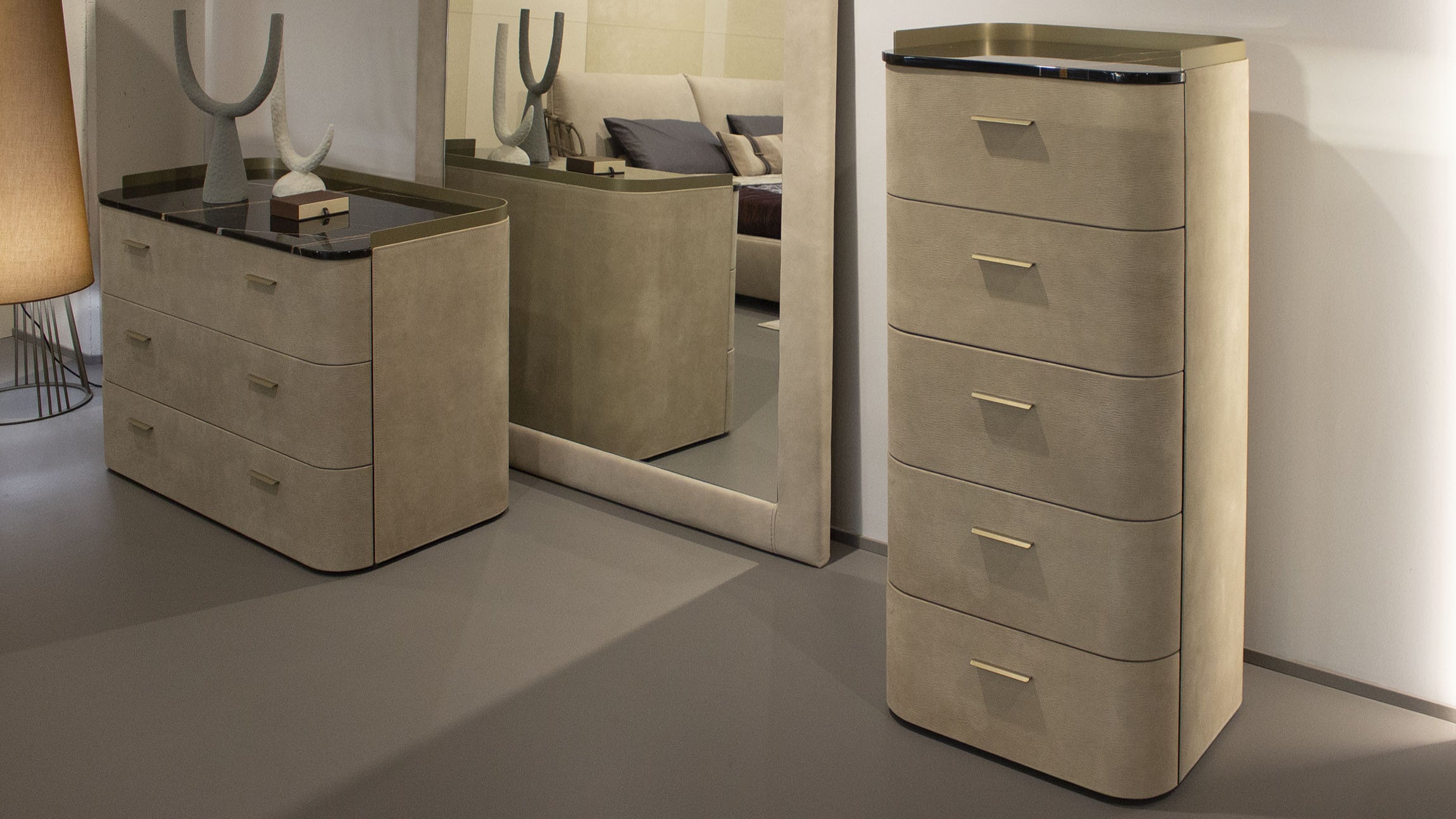 Beige bedroom furniture set with drawers and mirror in a room.